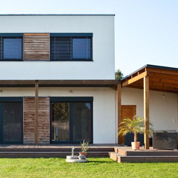 Modernes Einfamilienhaus mit Rasen und Carport